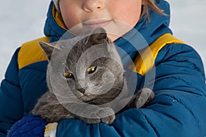 Boy plays with a cat outdoors