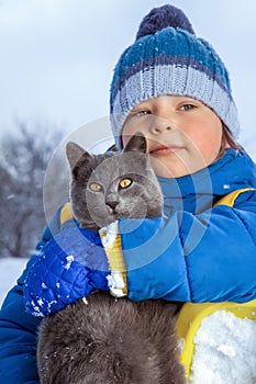 Boy plays with a cat outdoors focus on cat