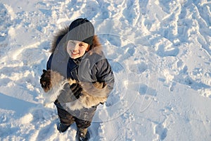 Boy plays with a cat in winter