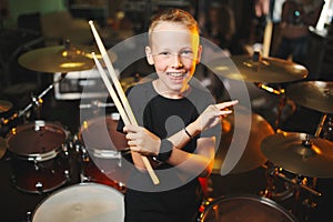 Boy plays drums in recording studio