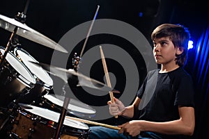 A boy plays drums in a recording studio
