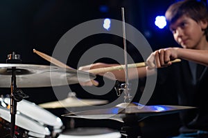 A boy plays drums in a recording studio
