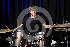 A boy plays drums in a recording studio