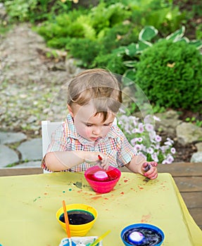 Boy Plays with a Easter Egg in Pink Dye