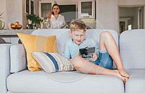 Boy plays with electronic device but his mother not happy with this