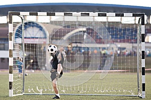 Boy plays football on stadium