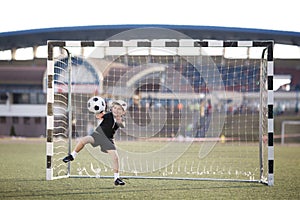 Boy plays football on stadium