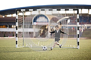 Boy plays football on stadium