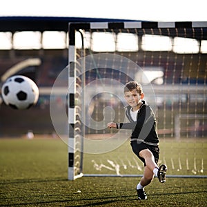 Boy plays football on stadium