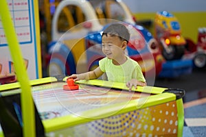 Boy plays game in arcade in mall playground concept