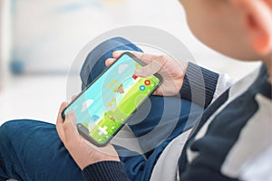 Boy plays the game on his phone. Concept of modern entertainment for children