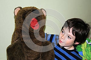 Boy plays with his large teddy bear