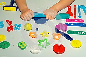 Boy plays with playdough on the table