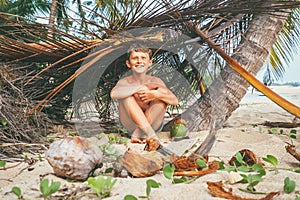 Boy plays in Robinzon on tropical beach in hut of branches