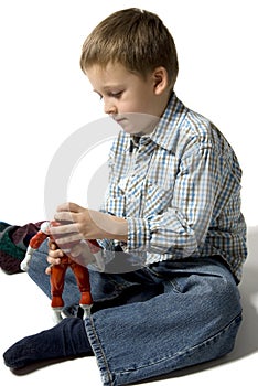 The boy plays with the robot