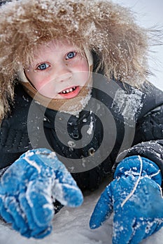The boy plays in the snow. Winter day