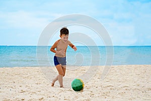 Boy plays soccer on beach