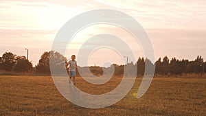 Boy plays with a toy plane in a field at sunset. The concept of childhood, freedom and inspiration.