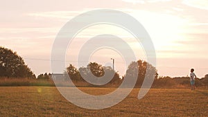 Boy plays with a toy plane in a field at sunset. The concept of childhood, freedom and inspiration.