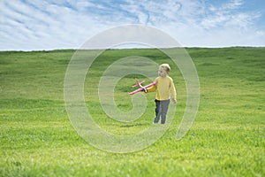 A boy plays in a toy red plane