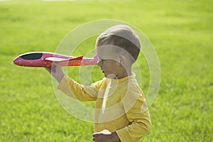 A boy plays in a toy red plane