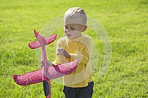 A boy plays in a toy red plane