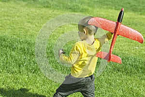 A boy plays in a toy red plane