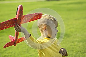 A boy plays in a toy red plane