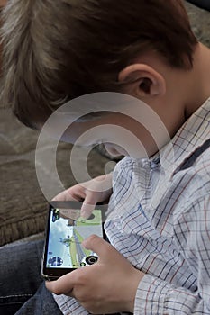 Boy playing a video game on mobile phone