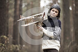 A boy plays in the woods with a toy plane. autumn games in the w