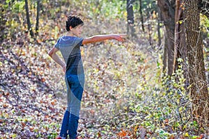 Boy Pointing at Something He Sees in the Woods photo