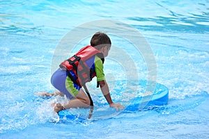 The boy in the pool in the summer autdoor. Holidays in the water Park. Joyful summer in the water photo