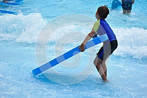 The boy in the pool in the summer autdoor. Holidays in the water Park. Joyful summer in the water photo