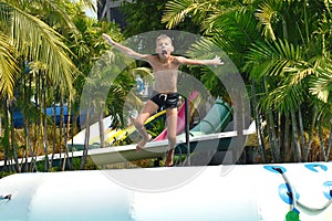 The boy in the pool in the summer autdoor. Holidays in the water Park. Joyful summer in the water photo