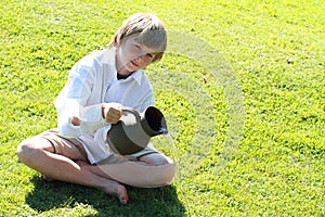 Boy pooring water from a pitcher