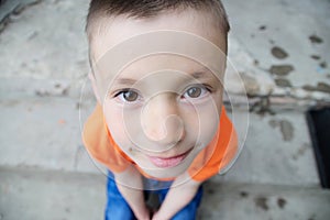 Boy portrait close-up top view. Smiling child face. Caucasian kid. fisheye effect. fish-eyed shot
