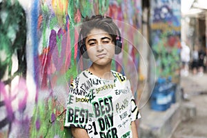 Boy portrait with earphones and grafiti behind