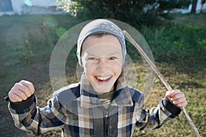 Boy portrait outdoor smiling grasping. happy smiling child outdoor playing warrior with stick