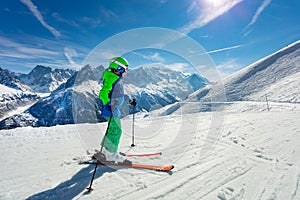 Boy portrait on snow slope over mountain peaks