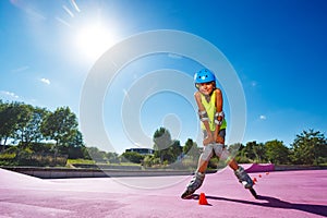 Boy pose standing on rollerblades in the skatepark