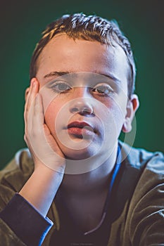 Boy posing for a portrait in my home studio agains a green backdrop