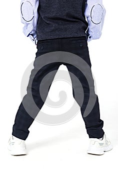 Boy posing in school uniform on white background. The boy shows clothes from the back.