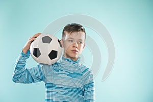Boy posing with soccer ball on blue studio background