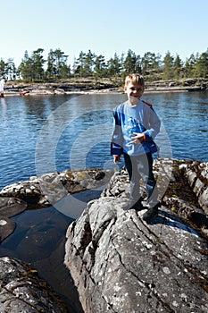 Boy posing on stone island in Ladoga skerries