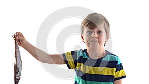 Boy posing in studio on a white background with raw fish, grimaces of disgust