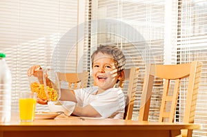 Boy pouring corn flakes making healthy breakfast