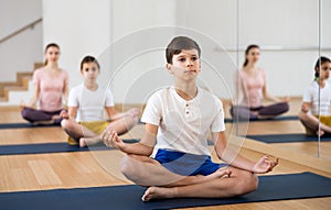 Boy practicing lotus pose during family yoga training