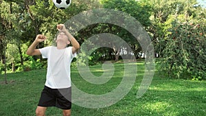 boy practicing and training in football tricks. kicks the ball in leg and head.