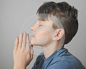 Boy Praying with Eyes Closed and Hands Folded
