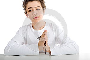 A boy is praying holding Rosary with both hands